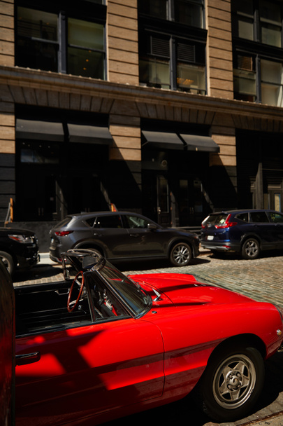 coche vintage rojo y otros vehículos aparcados cerca del edificio en la calle en la ciudad de Nueva York, escena urbana - Foto, Imagen