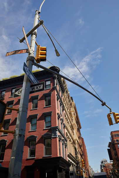 nízký úhel pohledu na pouliční sloup se silničními značkami a semafory v blízkosti budov v New Yorku - Fotografie, Obrázek