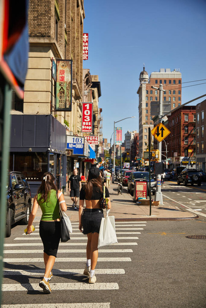 NEW YORK, USA - NOVEMBER 26, 2022: pedestrian on crosswalk of busy avenue in chinatown - Fotoğraf, Görsel