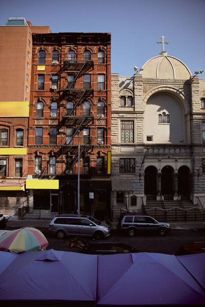 ニューヨーク市の赤レンガ造りの建物と教会の近くの道路を移動する車,都市の雰囲気 - 写真・画像