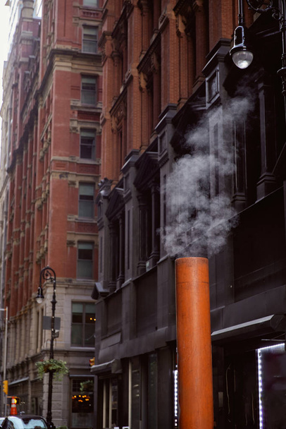 ニューヨーク市のダウンタウン地区の石造りの建物の近くで蒸気換気パイプ,街路面 - 写真・画像