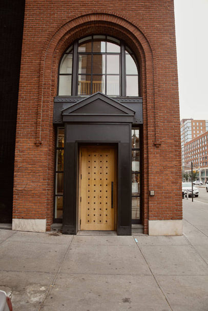 ingresso di edificio in mattoni con portico e finestra ad arco nel centro di New York, architettura urbana - Foto, immagini