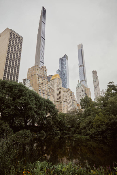 живописный вид на центральный парк против современных небоскребов в Нью-Йорке, сцена осеннего мегаполиса - Фото, изображение