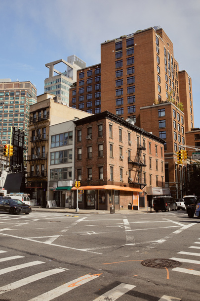 различные здания в стиле рядом с перекрестком с движущимися автомобилями в Нью-Йорке, городской архитектуры - Фото, изображение