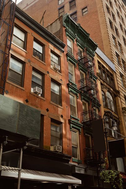 New York şehrinin klasik mimarisi, şehir merkezinde yangın merdivenleri olan kırmızı tuğlalı ev. - Fotoğraf, Görsel