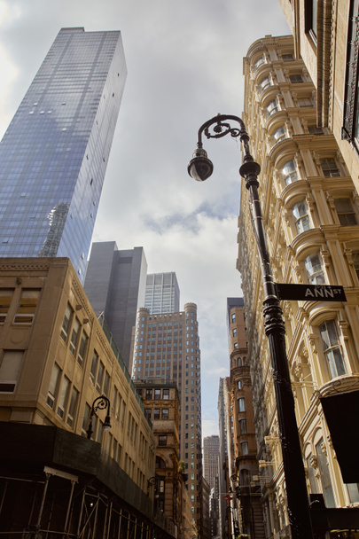 Blick auf geschmückte Laternen in der Nähe von historischen Gebäuden und modernen Wolkenkratzern in New York City - Foto, Bild
