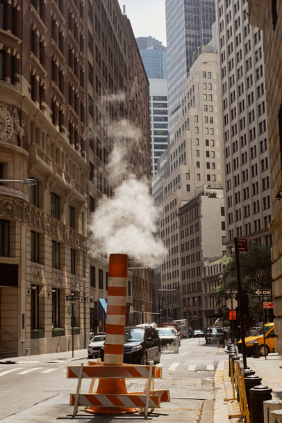 steam pipe on urban street with cars moving on roadway in new york city downtown, urban scene - Photo, Image