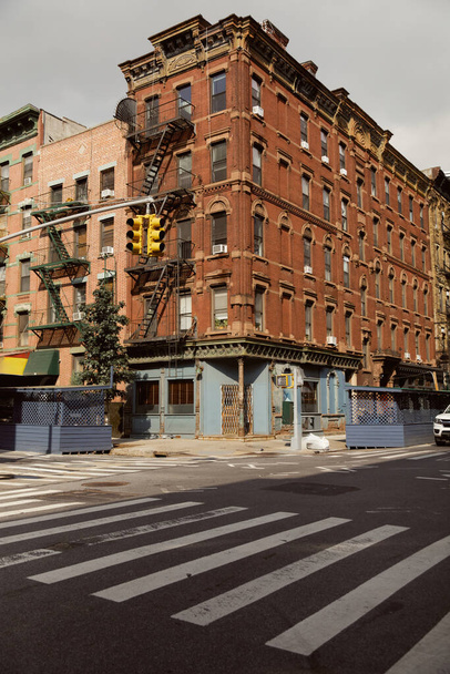 travessia pedestre perto de edifício vintage com escadas de escada de incêndio na cidade de Nova Iorque, streetscape - Foto, Imagem