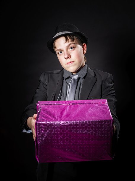 Expressive teenage boy holding box with gift - Фото, зображення