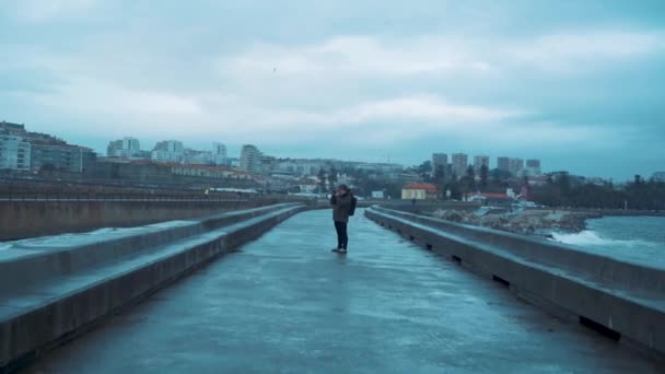 fiatal férfi hátizsákkal sétálgat az utcán éjszaka - Felvétel, videó