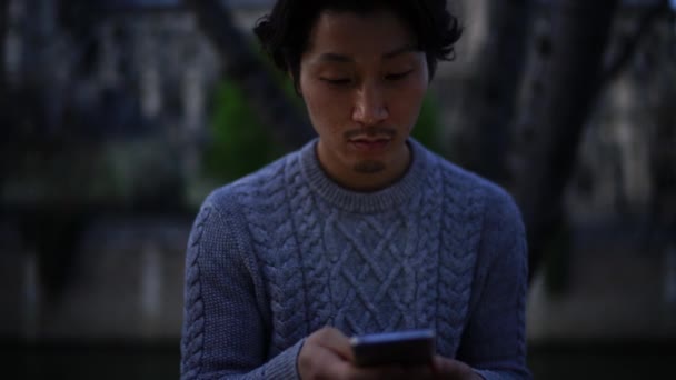 Aasian mies käyttää matkapuhelinta
 - Materiaali, video