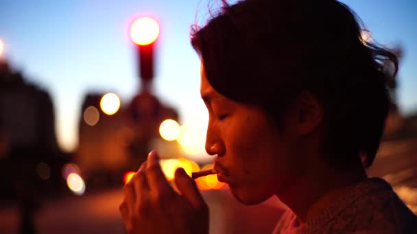 Asiatischer Mann raucht am Abend Zigarette - Filmmaterial, Video