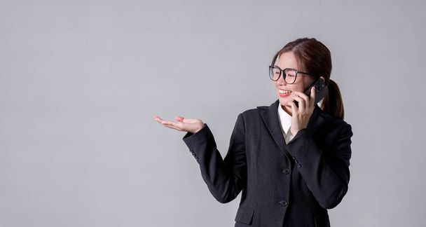 Портрет молодой деловой женщины, стоящей и разговаривающей по телефону, указывающей, фокусирующейся на мыслях.. - Фото, изображение