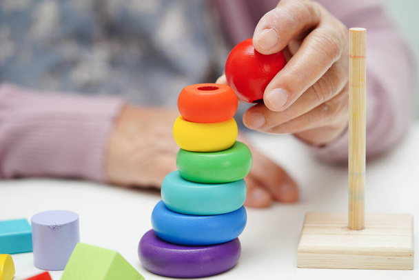 Aziatische oudere vrouw spelen puzzels spel om te oefenen hersenen training voor dementie preventie, ziekte van Alzheimer. - Foto, afbeelding