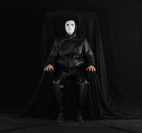 portret mężczyzny w dziwnej masce teatralnej na czarnym tle - Zdjęcie, obraz