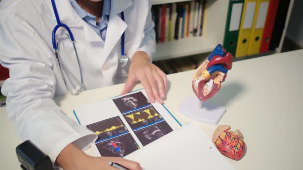 Kalp modelini hastaya gösteren kardiyoloji uzmanına yakın görüş ve hastanede hastalığı açıkla. - Video, Çekim