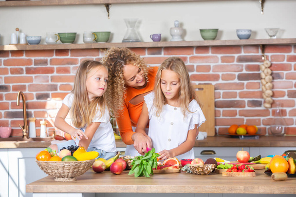 Мати і доньки готують разом на кухні. Концепція здорової їжі. Портрет щасливої родини зі свіжими коктейлями. Щасливі сестри. - Фото, зображення