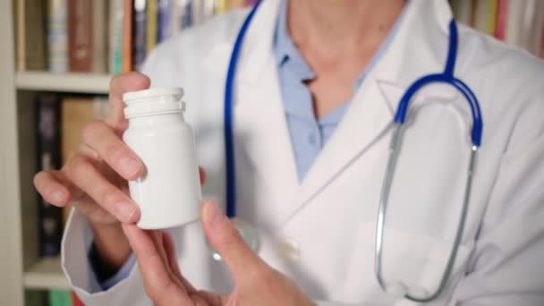 Primer plano médico femenino lleva abrigo blanco en el hospital y la celebración de píldoras - Metraje, vídeo