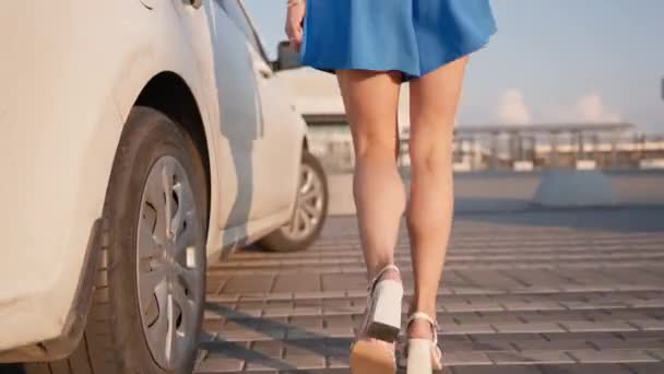 Seductive Woman with Slim Legs and Figure Walks and Sits in a White Car in the Drivers Seat. Attractive Girl Driver in a Short Skirt Gets into the Car. - Footage, Video