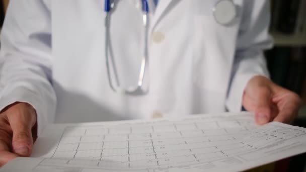 Крупный план женщина-врач носит белый халат стоит в больнице и держит папку с документами документы, диагнозы, рецепты - Кадры, видео