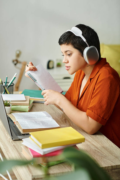 vertical shot of young attractive student with headphones studying hard and looking at laptop - Photo, Image