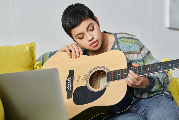 mujer joven concentrada aprendiendo a tocar la guitarra en una lección de música remota, educación en casa - Foto, Imagen