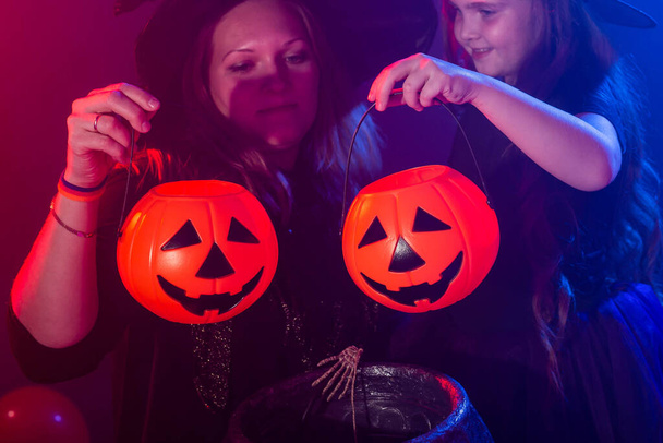 Смешные девочка и женщина в костюмах ведьм на Хэллоуин с тыквой Джек и собака - Фото, изображение