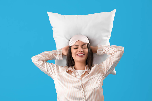 Hübsche junge Frau schläft auf blauem Hintergrund - Foto, Bild
