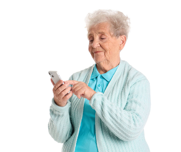 Seniorin benutzt Handy auf weißem Hintergrund - Foto, Bild
