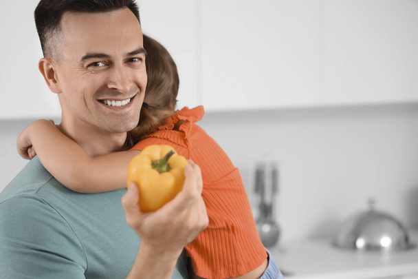 Pai feliz com pimentão e sua filha na cozinha, close-up - Foto, Imagem