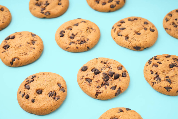 Biscoitos saborosos com chips de chocolate no fundo azul - Foto, Imagem