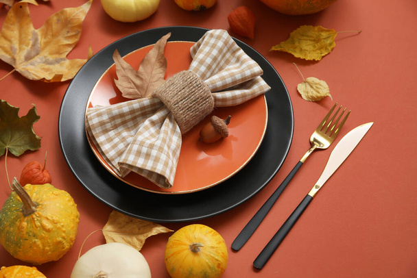 Gyönyörű őszi asztal beállítás sütőtök és levelek burgundi háttér - Fotó, kép