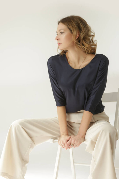 Serie studio kuvia nuori nainen malli yllään yksinkertainen kaunis asu, silkki satiini pusero ja valkoinen leveä jalka housut  - Valokuva, kuva