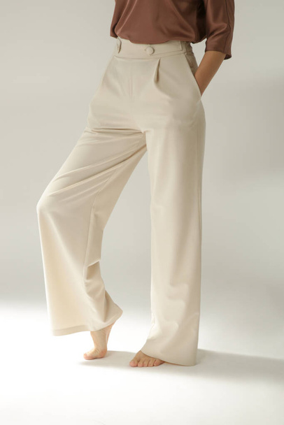 Ženská modelka v béžových elegantních neformálních kalhotách. Studio shot - Fotografie, Obrázek