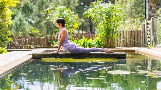 Жінка, що практикує йогу, лежить у позі Cobra (вправа Бхуджяханасани) на відкритому повітрі - Фото, зображення