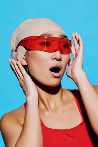 Frau weiße positive Sonnenbrille Haare lächelnd trendige Brille Gesicht Strand Spaß Emotion Lifestyle Eleganz rot Badeanzug asiatisch Modell Mode Porträt Schönheit blau - Foto, Bild