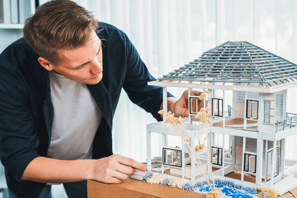 Architect designer reviewing house frame model with no wall, brainstorming interior design and improvement idea with actual home scale. Professional and creativity in architectural design. Iteration - Photo, Image