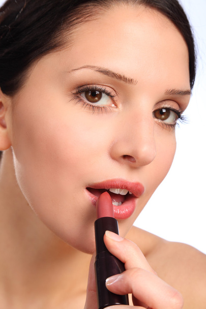 Beautiful young woman lipstick cosmetics to lips - Foto, Imagem