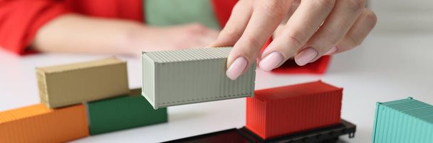 Managers hand arranges cargo containers and railcars on table. Concept of delivery of goods, transport and logistics. - Photo, Image