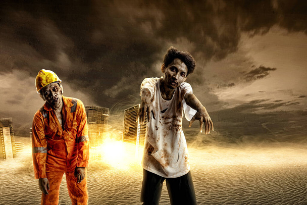 Two scary zombies with blood and wounds on his body are walking in the ruined city. Scary zombie. Halloween concept - Foto, Bild