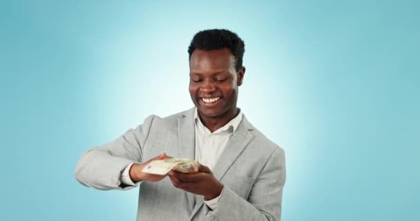 Hombre negro feliz, dinero y baile para celebrar en libertad financiera contra un fondo de estudio azul. Empresario africano entusiasmado con flujo de caja, beneficio o salario por inversión, ahorro o crecimiento. - Imágenes, Vídeo