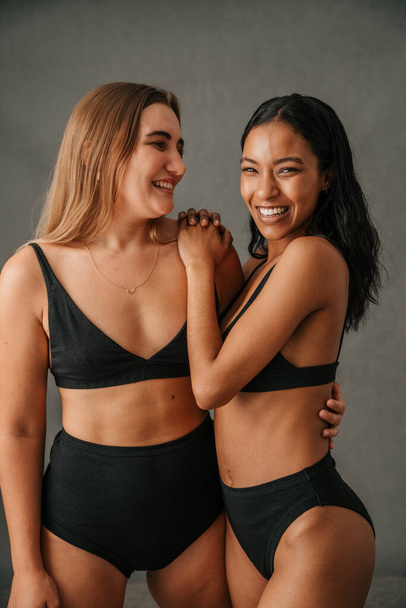  Portrait of two fun loving diverse girlfriends posing in the studio. High quality photo - Photo, Image