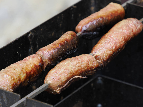 Grigliare salsicce bavaresi sulla griglia barbecue a carbone barbecue in giardino - Foto, immagini