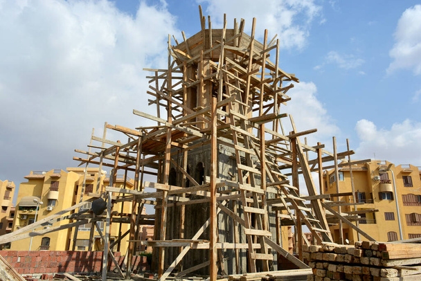 Una nueva mezquita en construcción, la construcción de una nueva gran mezquita de Masjid en El Cairo, Egipto, con una gran cúpula y alto minarete, andamios de madera, mezquitas están rezando lugar para los musulmanes para realizar su oración - Foto, Imagen