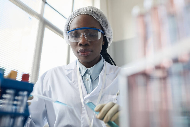 黒人女性科学者の肖像画は,研究室での実験中に保護眼鏡をかけている. - 写真・画像