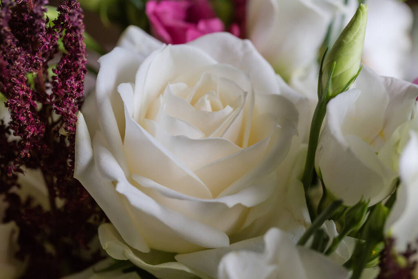Rosa blanca entre las otras rosas multicolores y eustoma blanco en el ramo, fragmento de primer plano - Foto, Imagen