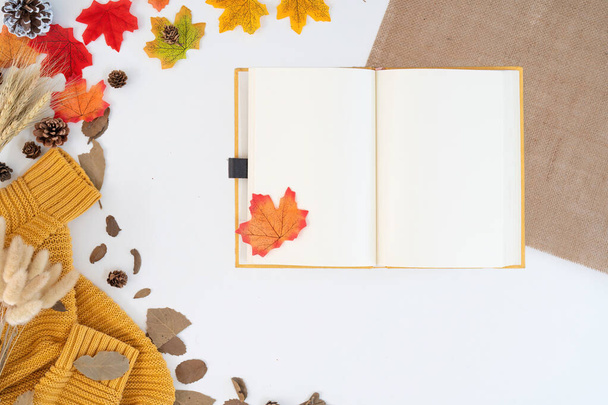 Modern office desk with coffee cup, notebook, yellow-red autumn leaves on white background with copy space. Place for your text. work table with office supplies. concept cosy, cozy, seasonal autumn. - Photo, Image