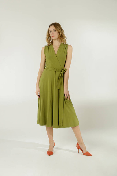 Serie of studio photos of young female model in green viscose wrap dress.  - Photo, Image