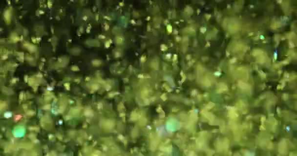 Πολύχρωμο πράσινο γκλίτερ που πετάει στον αέρα. Όμορφο Χριστουγεννιάτικο φόντο - Πλάνα, βίντεο