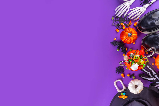 Яркие красочные Хэллоуин детей партии аксессуары фон, лечить или трюк праздник с красочными конфеты, традиционные Хэллоуин символов костюмы, сладости, конфеты и декор сверху - Фото, изображение